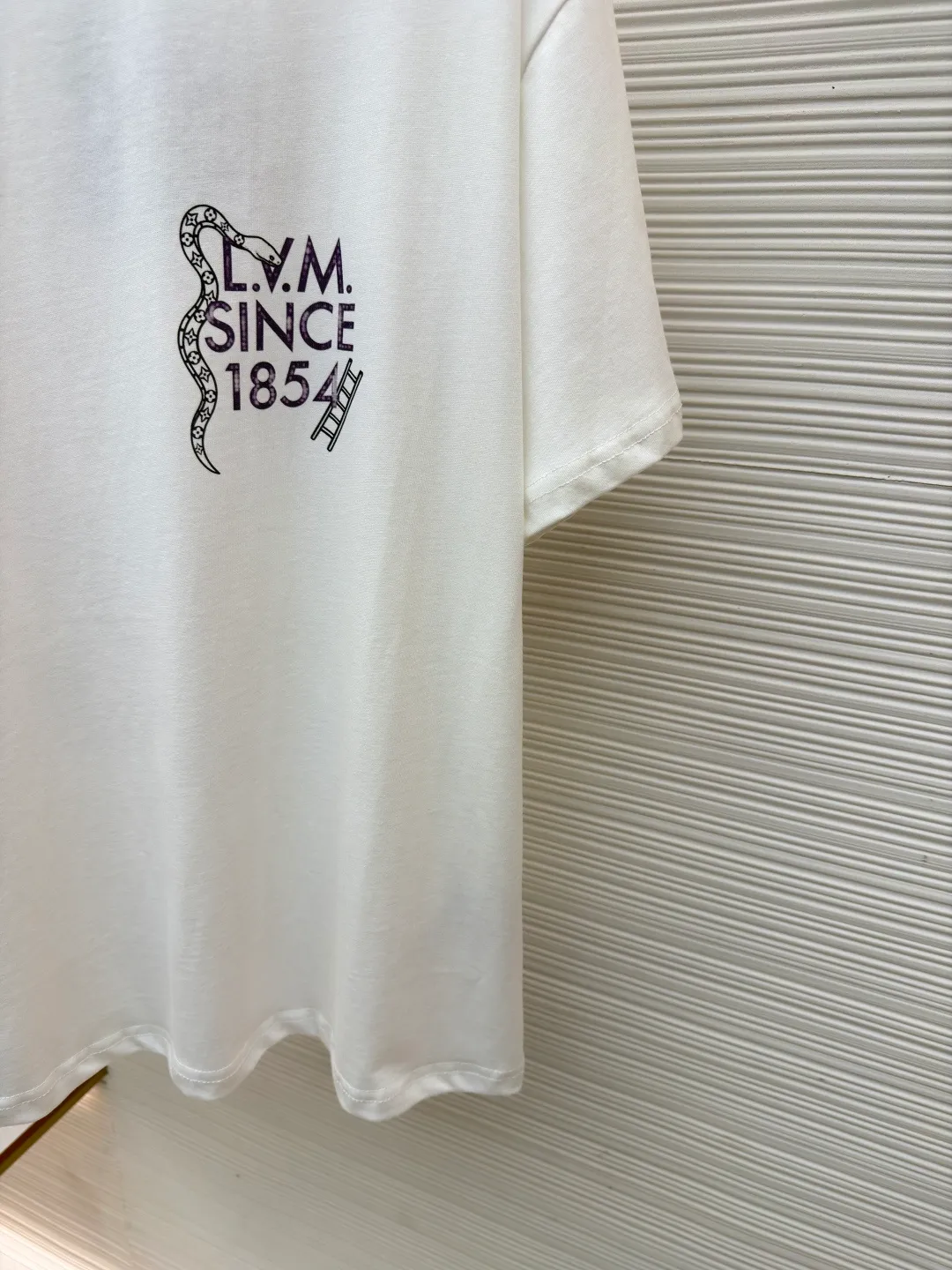 LOUIS VUITTON round neck printed short-sleeved T-shirt ●Original version: Purchased and developed at 7450 ●Item number: 1682214-A10 ●Fabric: cotton fabric ●Technology: Printing ●Color: white ●Version: fitted version ●Weight: about 260 grams ●Size: S-M-L-XL ●Description: This printed short-sleeved T-shirt is made using high-end garment technology. The fabric is made of 230g heavyweight double-strand combed cotton. It is treated with an enzyme washing process to make the cotton soft to the touch and not easy to pill or deform, while retaining the breathability and skin-friendly properties of cotton. The back theme printing uses a composite process of digital direct inkjet printing and screen printing. First, digital direct inkjet printing is used to restore the color gradation and delicate texture of the pattern, and then screen printing is used to outline the outline of the pattern, which increases the color firmness of the printing by 30% and does not fade or crack after repeated washing. The neckline is hemmed with two stitches and is paired with high-elastic rib fabric, which is resistant to pulling and does not deform after long-term wear. The side seams and shoulder seams of the body are sewn with embedded clip technology, and the stitching is fine and smooth. The overall shape is created through three-dimensional tailoring to create a loose shoulder drop effect, taking into account both wearing comfort and stiffness. The overall wiring is straight and delicate, the fabric is comfortable and soft, and the color is consistent without color difference. It can be matched with the same style to create a fashionable look and control various occasions. Customized accessories, complete with three standards, same style for men and women!